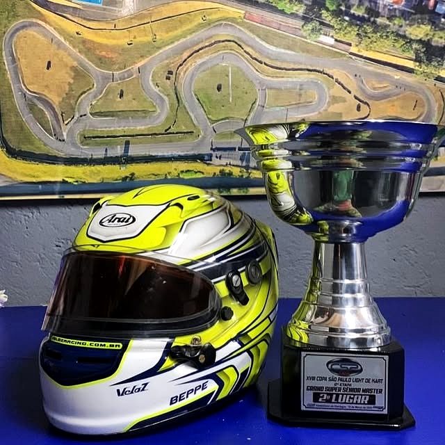 Capacete de piloto ao lado de um troféu da Copa São Paulo Light de Kart